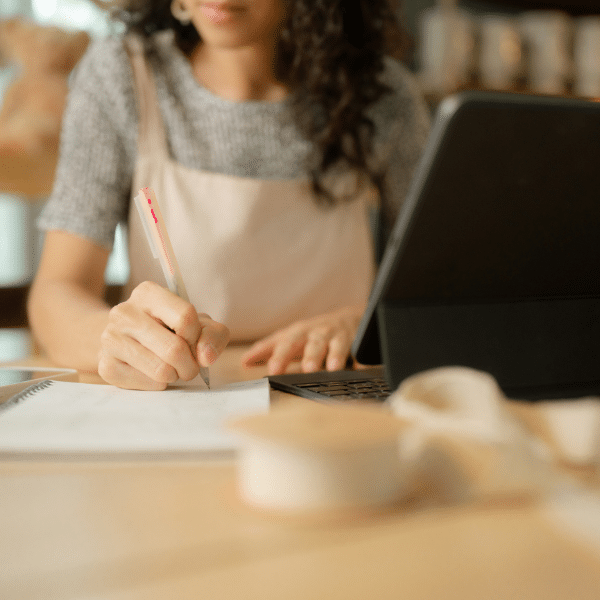 Woman writing reflections during a self-development coaching session, practicing clarity and personal growth.