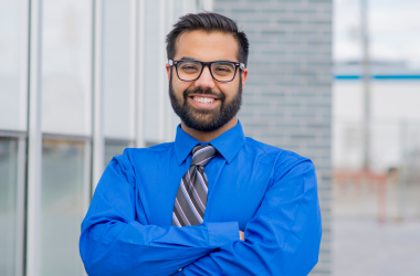 Confident man smiling with folded arms, representing Iyali’s Confidence & Self-Love Flower Medicine session for self-trust and emotional healing.