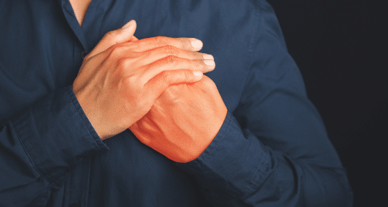 Person holding their chest due to anxiety-related heart palpitations, symbolizing physical symptoms addressed at Iyali Counselling