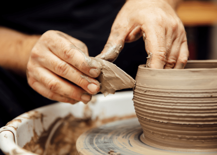 Hands shaping clay on a pottery wheel during a mindful clay therapy and pottery session at Iyali