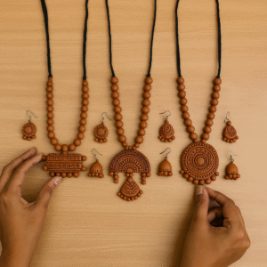 Hands arranging completed terracotta necklace and earring sets during the jewellery-making essentials session at Iyali Terracotta Classes in Chennai.