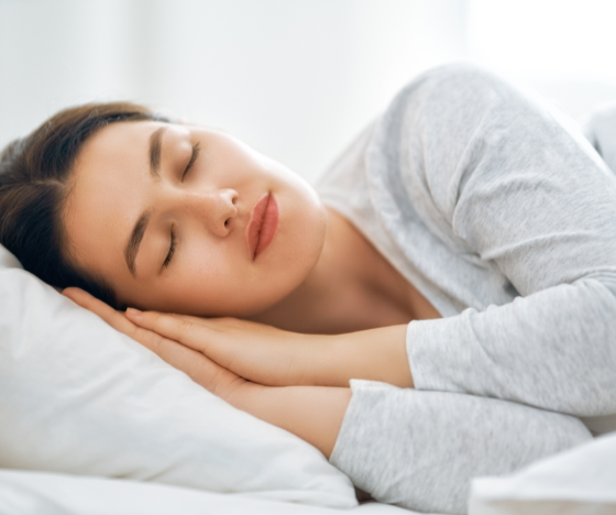 Woman sleeping peacefully on a pillow during a restorative sleep improvement therapy session.